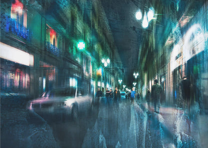 An abstract, moody artwork of a busy city street at night, viewed as if through a rainy window or with motion blur. The scene is dominated by shades of deep blue and vibrant green, with glowing streetlights and neon signs casting reflections on the wet pavement. Silhouettes of people walk down the street, and a car is partially visible on the left. The entire composition has a dynamic, dreamlike quality and is presented in a silver frame. Poster