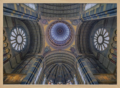 An upward-looking view of the highly ornate vaulted ceiling of a grand cathedral, featuring a central glass dome, large rose windows, and intricate gold and blue details, all framed in silver. Poster