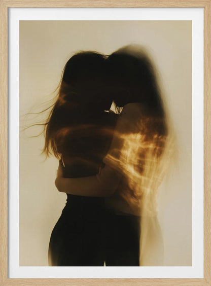 An artistic, long-exposure photograph of two silhouetted figures embracing. Their forms are blurred with motion, and streaks of warm, golden light wash over them against a soft, off-white background, creating a dreamy and intimate mood. Decor