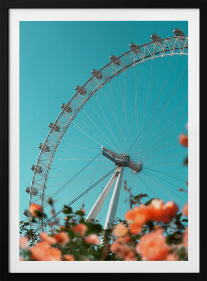 A low-angle shot of the London Eye ferris wheel against a clear, vibrant teal sky. In the foreground, out-of-focus orange flowers create a soft, colorful frame. Poster