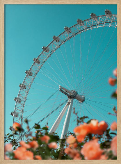 A low-angle shot of the London Eye ferris wheel against a clear, vibrant teal sky. In the foreground, out-of-focus orange flowers create a soft, colorful frame. Poster