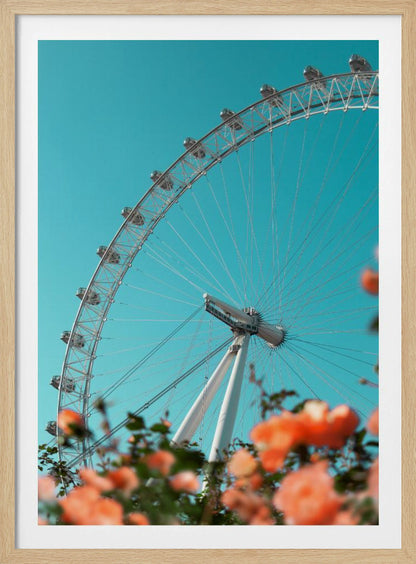 A low-angle shot of the London Eye ferris wheel against a clear, vibrant teal sky. In the foreground, out-of-focus orange flowers create a soft, colorful frame. Poster
