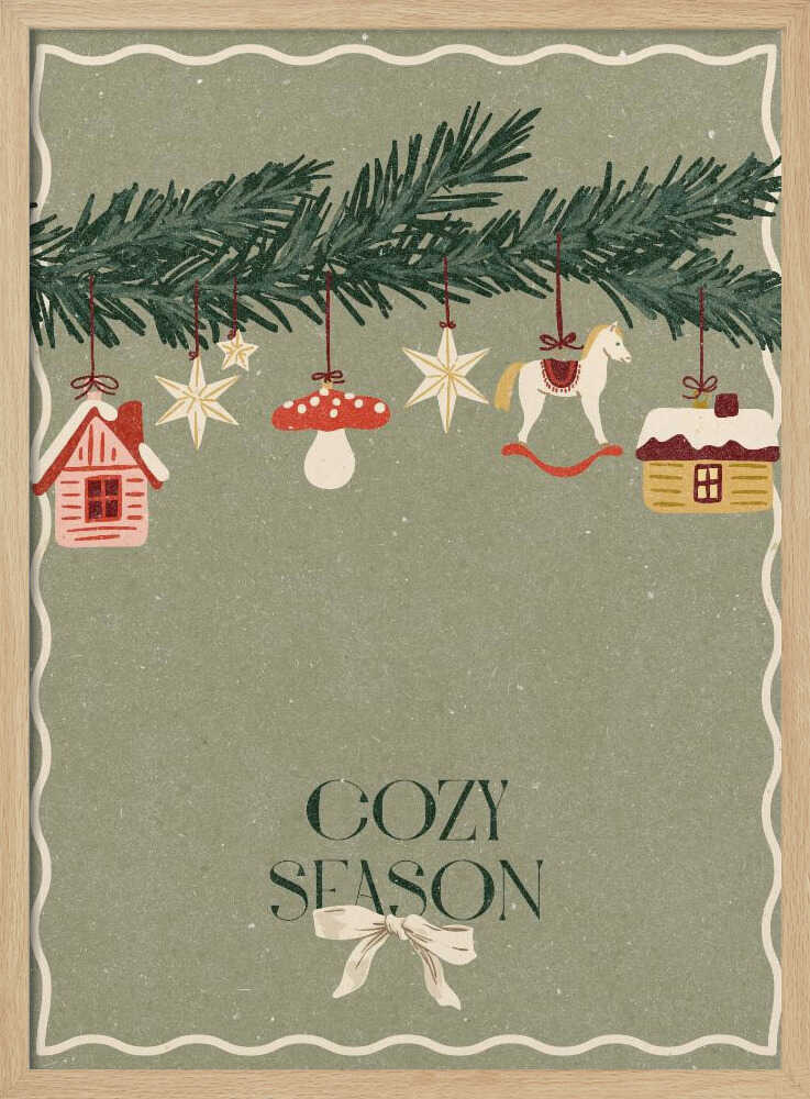 A vintage-style holiday poster with a sage green background. A pine branch hangs at the top, decorated with illustrated ornaments including houses, stars, a mushroom, and a rocking horse. Below, the text 'COZY SEASON' is written in a dark serif font with a light-colored bow underneath. Artwork