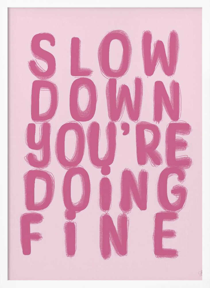 A framed art print featuring the phrase 'SLOW DOWN YOU'RE DOING FINE' in a bold, dark pink, brush-stroke font. The words are stacked vertically against a light pink background, all enclosed within a simple black frame. Artwork