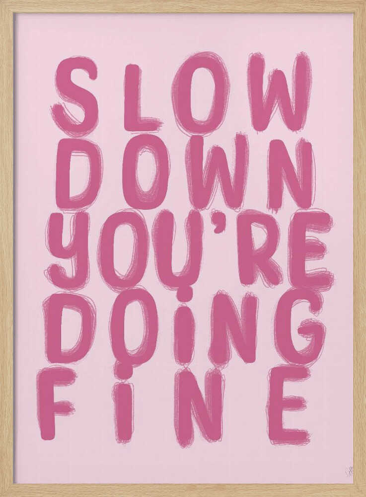 A framed art print featuring the phrase 'SLOW DOWN YOU'RE DOING FINE' in a bold, dark pink, brush-stroke font. The words are stacked vertically against a light pink background, all enclosed within a simple black frame. Artwork