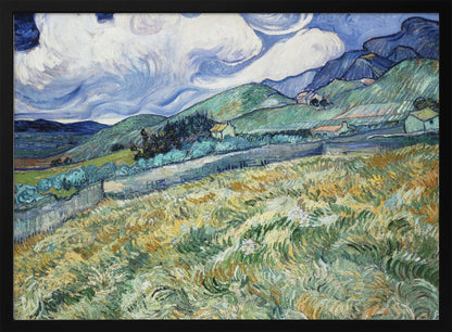 A framed Post-Impressionist painting by Vincent van Gogh depicting a vibrant, rolling landscape. The foreground is filled with swirling brushstrokes of green and yellow fields, leading back to green hills dotted with small houses. In the background, dark blue mountains rise up to meet a dramatic sky filled with large, swirling white clouds against a deep blue. Wall Art