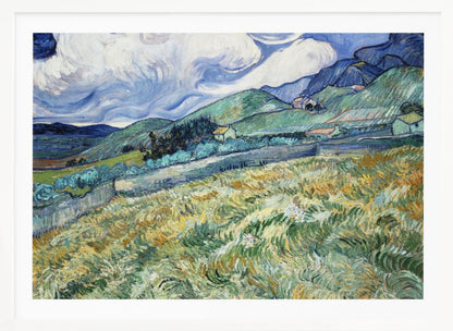 A framed Post-Impressionist painting by Vincent van Gogh depicting a vibrant, rolling landscape. The foreground is filled with swirling brushstrokes of green and yellow fields, leading back to green hills dotted with small houses. In the background, dark blue mountains rise up to meet a dramatic sky filled with large, swirling white clouds against a deep blue. Wall Art