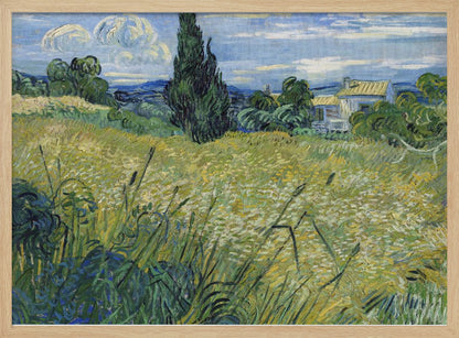 Vincent van Gogh's painting 'Green Wheat Field with Cypress' in a silver frame. The artwork features a vibrant golden-yellow field with green stalks in the foreground, a towering dark green cypress tree at the center, and a small farmhouse in the background under a blue sky with stylized, swirling white clouds. The entire scene is rendered in the artist's characteristic thick, expressive brushstrokes. Print