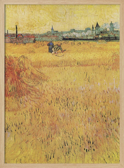 A Post-Impressionist painting by Vincent van Gogh depicting a vast, golden wheat field under a yellow sky. Two figures are harvesting wheat in the middle distance, with a town and industrial buildings on the horizon. The artwork is characterized by thick, textured brushstrokes and is displayed in a black frame. Print
