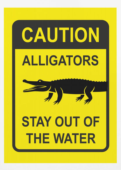 A yellow and black rectangular warning sign in a black frame. The sign reads 'CAUTION ALLIGATORS' at the top, features a black silhouette of an alligator in the center, and says 'STAY OUT OF THE WATER' at the bottom. Decor