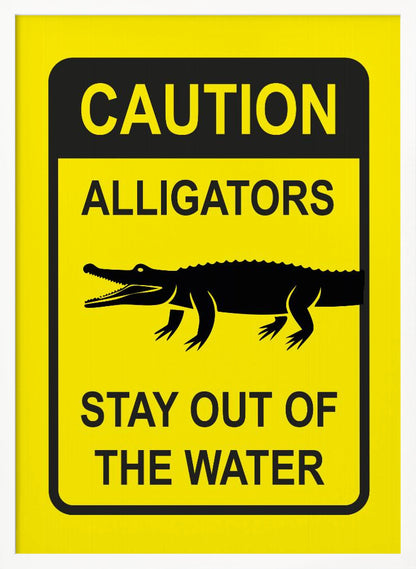 A yellow and black rectangular warning sign in a black frame. The sign reads 'CAUTION ALLIGATORS' at the top, features a black silhouette of an alligator in the center, and says 'STAY OUT OF THE WATER' at the bottom. Decor