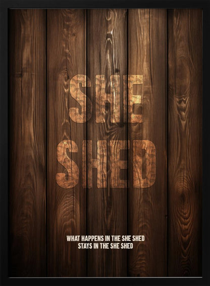 A rustic poster with a dark brown wood panel background. The words 'SHE SHED' are in large, blocky letters with a distressed wood texture. Below, a smaller caption reads 'WHAT HAPPENS IN THE SHE SHED STAYS IN THE SHE SHED'. The poster is displayed in a thin black frame. Print