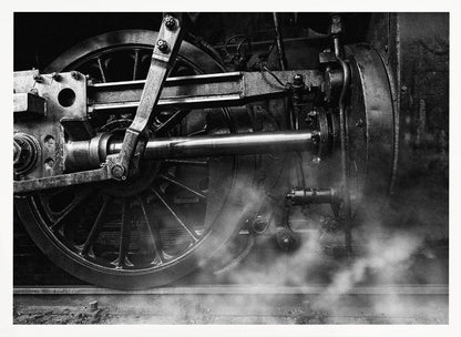 A dramatic, black and white close-up photograph of the wheels and driving rods of a steam locomotive. Puffs of steam rise from the tracks, partially obscuring the lower part of the machinery. Print