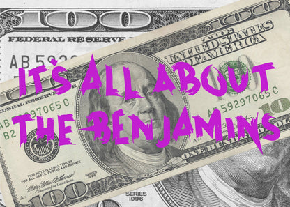 A pop art piece featuring a close-up of a one-hundred-dollar bill. The phrase 'IT'S ALL ABOUT THE BENJAMINS' is written across the image in a messy, graffiti-style font in a vibrant magenta color. The artwork is set within a silver frame. Wall Art