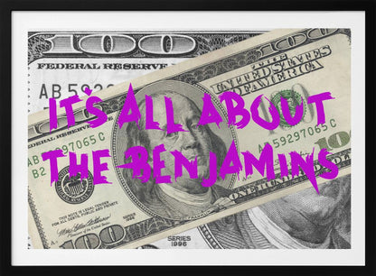 A pop art piece featuring a close-up of a one-hundred-dollar bill. The phrase 'IT'S ALL ABOUT THE BENJAMINS' is written across the image in a messy, graffiti-style font in a vibrant magenta color. The artwork is set within a silver frame. Wall Art