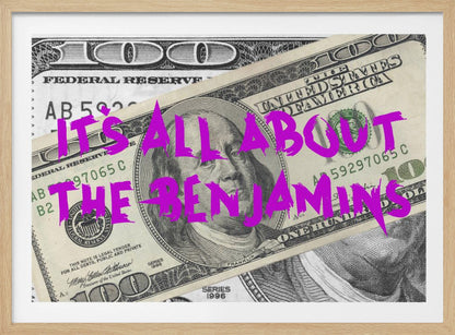 A pop art piece featuring a close-up of a one-hundred-dollar bill. The phrase 'IT'S ALL ABOUT THE BENJAMINS' is written across the image in a messy, graffiti-style font in a vibrant magenta color. The artwork is set within a silver frame. Wall Art
