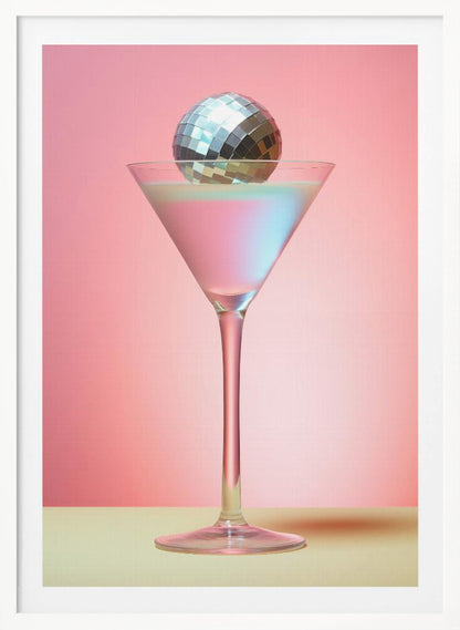 A sleek martini glass filled with an iridescent pink and blue cocktail is centered against a solid pink background. A small, shiny silver disco ball rests on the rim of the glass, completing the festive and stylish composition. Decor