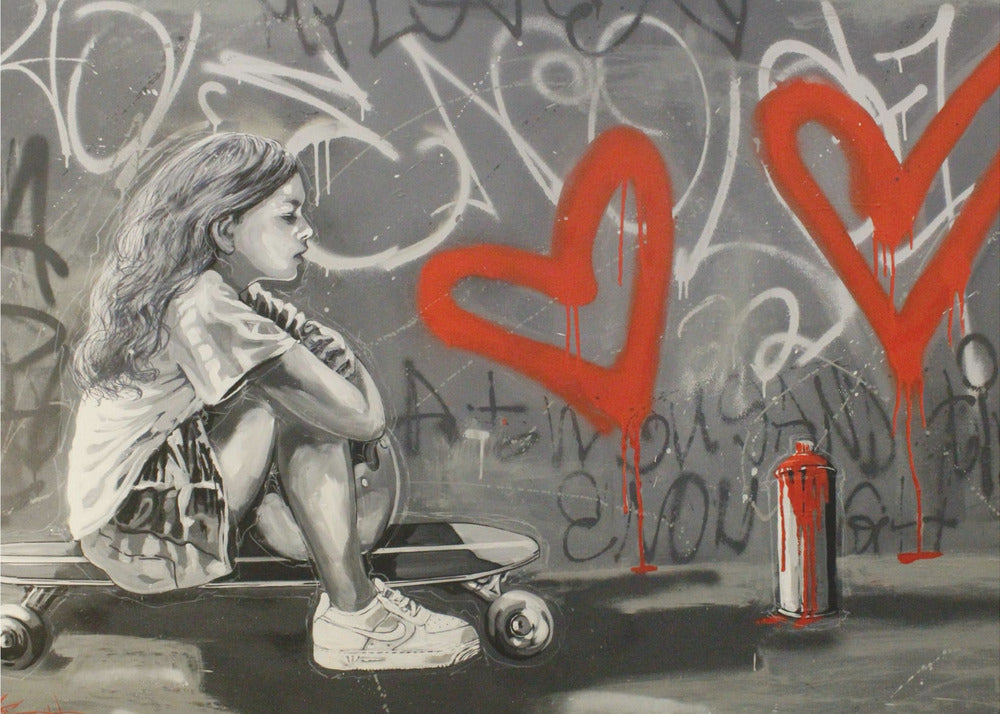 A monochrome street art painting of a young girl with long hair sitting thoughtfully on a skateboard. Behind her, a grey wall is covered in graffiti tags and two large, bright red hearts are spray-painted with drips running down. A red and white spray paint can sits on the ground next to her. Artwork