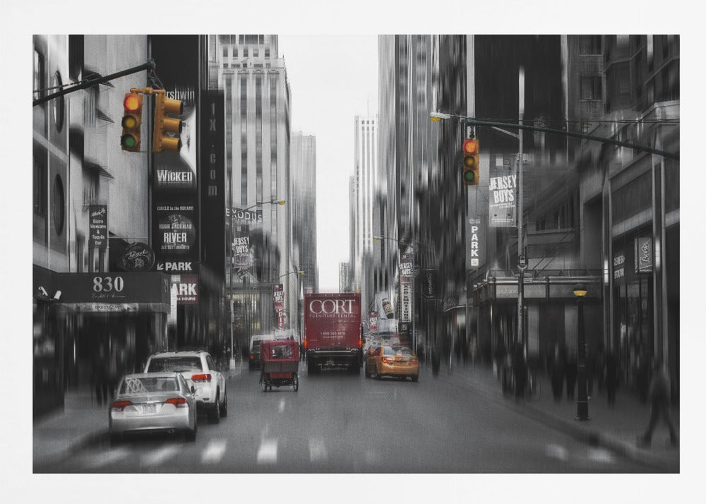 A framed, stylized photograph of a busy New York City street, presented mostly in black and white with a motion blur effect. Pops of color highlight red vehicles and yellow traffic lights, drawing focus down the urban canyon lined with skyscrapers and Broadway signs. Decor