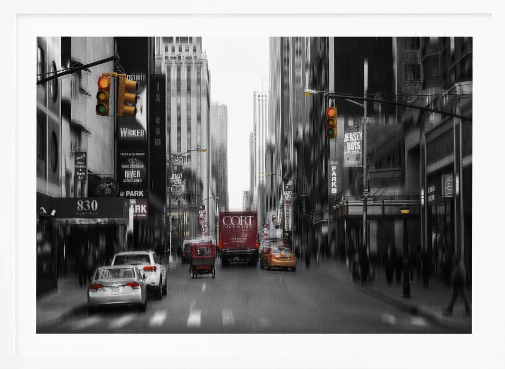 A framed, stylized photograph of a busy New York City street, presented mostly in black and white with a motion blur effect. Pops of color highlight red vehicles and yellow traffic lights, drawing focus down the urban canyon lined with skyscrapers and Broadway signs. Decor