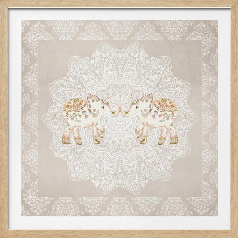 A framed artwork depicting two small, ornate elephants facing each other in the center, their trunks touching. They are decorated with colorful floral patterns and stand against a large, intricate white mandala on a light beige background. The piece is bordered with a white pattern and set in a light wood frame. Wall Art