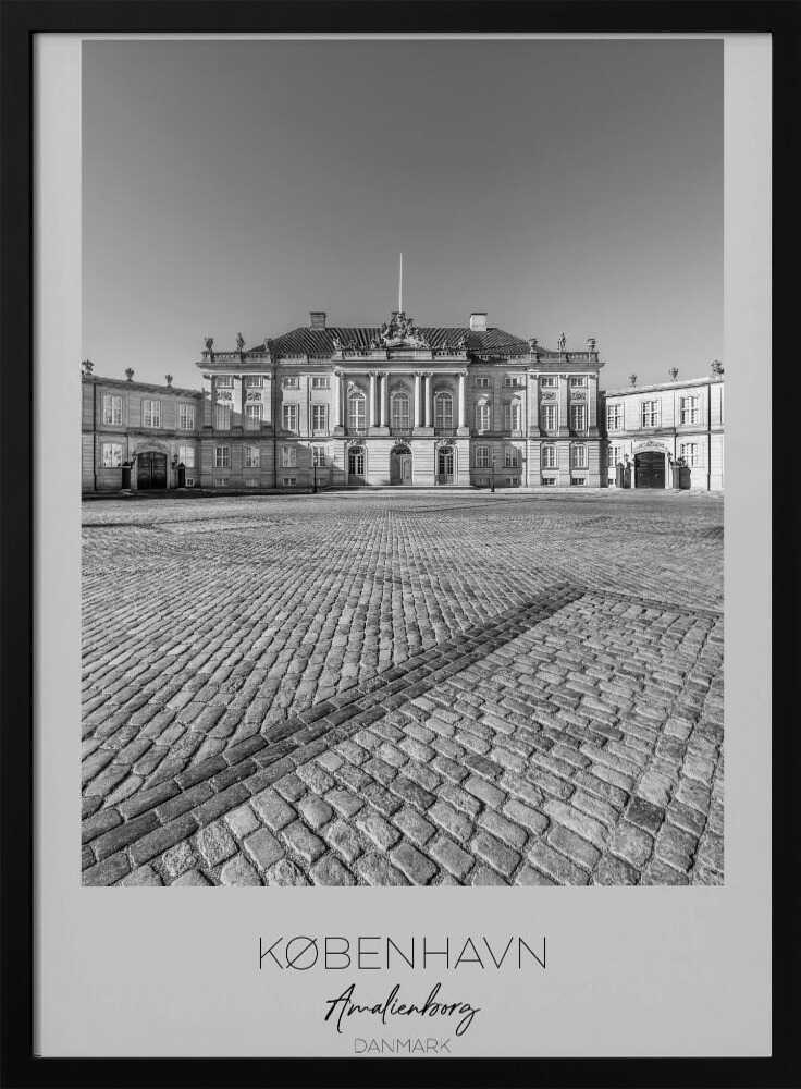 A framed, vertical black and white photograph of Amalienborg Palace in Copenhagen. The shot is taken from a low angle, emphasizing the large cobblestone square in the foreground. The palace stands symmetrically in the background under a clear sky. At the bottom of the poster, text reads 'KØBENHAVN', 'Amalienborg', and 'DANMARK'. Poster