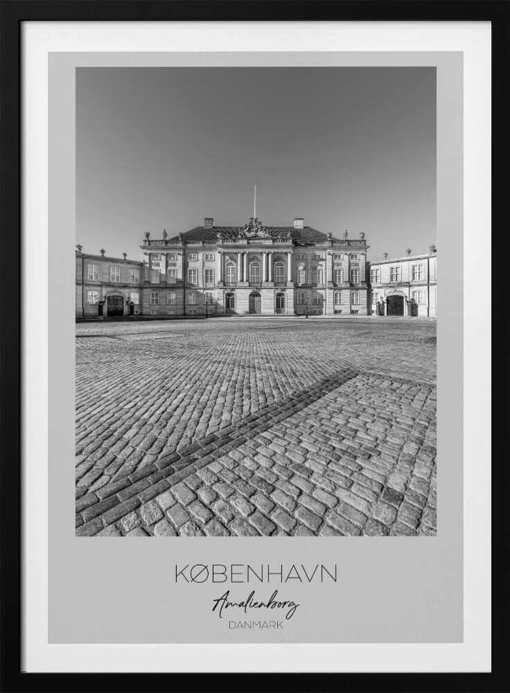 A framed, vertical black and white photograph of Amalienborg Palace in Copenhagen. The shot is taken from a low angle, emphasizing the large cobblestone square in the foreground. The palace stands symmetrically in the background under a clear sky. At the bottom of the poster, text reads 'KØBENHAVN', 'Amalienborg', and 'DANMARK'. Poster