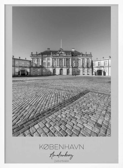 A framed, vertical black and white photograph of Amalienborg Palace in Copenhagen. The shot is taken from a low angle, emphasizing the large cobblestone square in the foreground. The palace stands symmetrically in the background under a clear sky. At the bottom of the poster, text reads 'KØBENHAVN', 'Amalienborg', and 'DANMARK'. Poster
