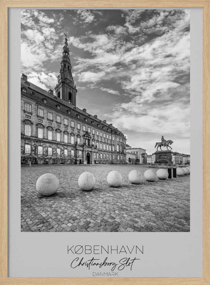 A black and white travel poster of Christiansborg Palace in Copenhagen, Denmark. The image shows the grand building and its tower against a dramatic cloudy sky, with a cobblestone square, stone bollards, and an equestrian statue in the foreground. Text at the bottom identifies the location. Decor