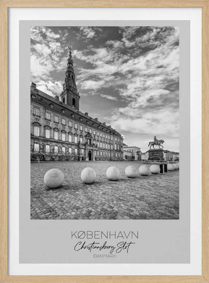 A black and white travel poster of Christiansborg Palace in Copenhagen, Denmark. The image shows the grand building and its tower against a dramatic cloudy sky, with a cobblestone square, stone bollards, and an equestrian statue in the foreground. Text at the bottom identifies the location. Decor