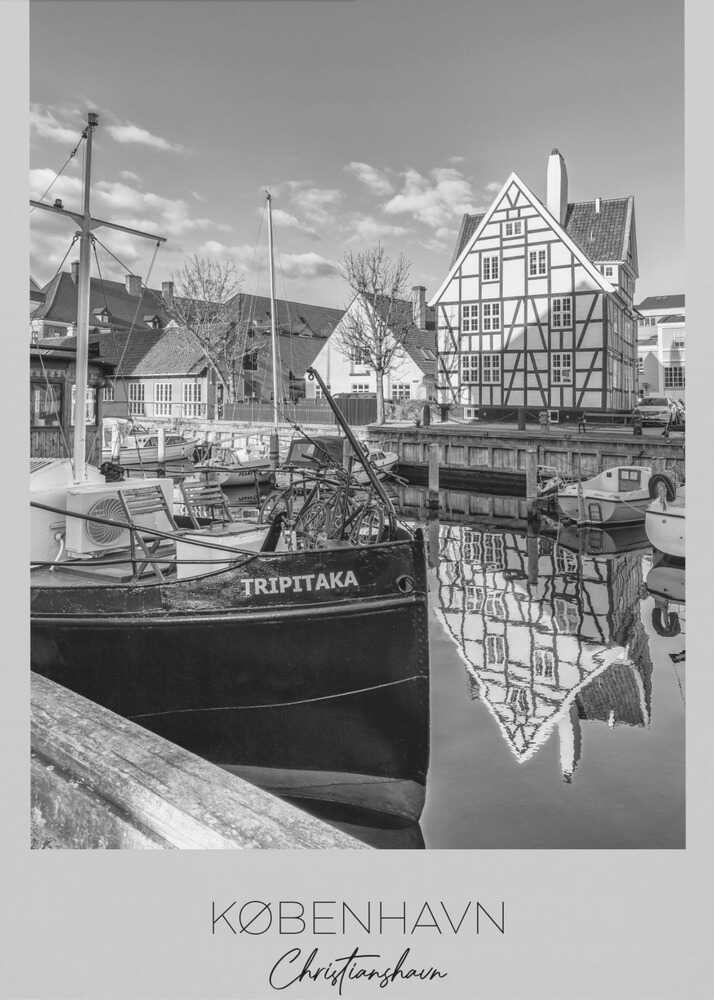 A black and white travel poster featuring a photo of Christianshavn in Copenhagen. The scene shows a boat named 'TRIPITAKA' docked in a canal, with a prominent half-timbered building across the water, its reflection visible on the surface. The bottom of the poster has text that reads 'KØBENHAVN', 'Christianshavn', and 'DANMARK'. Artwork