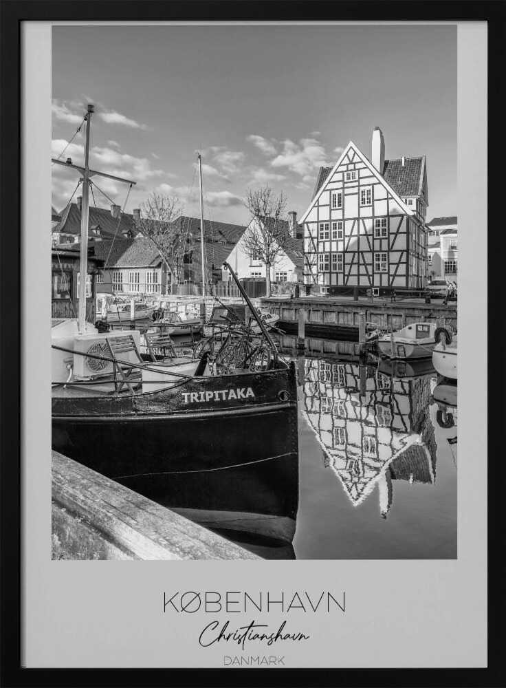 A black and white travel poster featuring a photo of Christianshavn in Copenhagen. The scene shows a boat named 'TRIPITAKA' docked in a canal, with a prominent half-timbered building across the water, its reflection visible on the surface. The bottom of the poster has text that reads 'KØBENHAVN', 'Christianshavn', and 'DANMARK'. Artwork