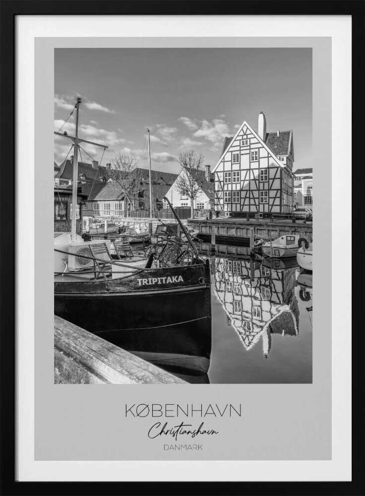 A black and white travel poster featuring a photo of Christianshavn in Copenhagen. The scene shows a boat named 'TRIPITAKA' docked in a canal, with a prominent half-timbered building across the water, its reflection visible on the surface. The bottom of the poster has text that reads 'KØBENHAVN', 'Christianshavn', and 'DANMARK'. Artwork