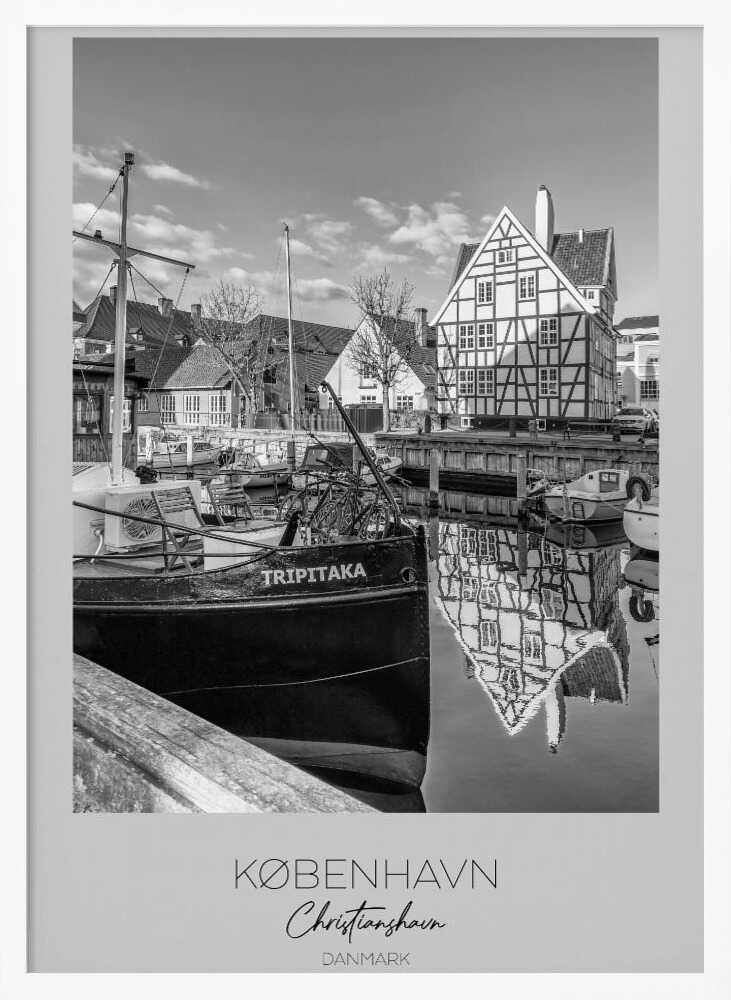 A black and white travel poster featuring a photo of Christianshavn in Copenhagen. The scene shows a boat named 'TRIPITAKA' docked in a canal, with a prominent half-timbered building across the water, its reflection visible on the surface. The bottom of the poster has text that reads 'KØBENHAVN', 'Christianshavn', and 'DANMARK'. Artwork