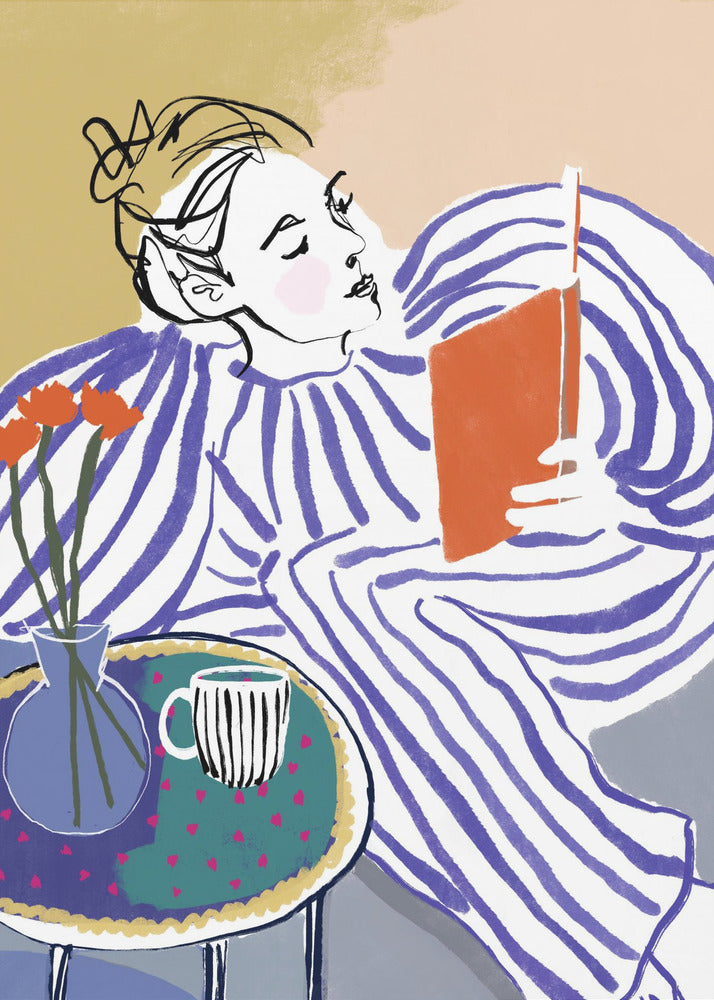 A stylized, framed illustration of a person with dark hair in a messy bun, wearing a blue and white striped top, reclining comfortably while engrossed in an orange book. Beside them is a small table with a blue vase holding three orange flowers and a black and white striped mug. The background is a soft beige color. Print