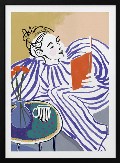 A stylized, framed illustration of a person with dark hair in a messy bun, wearing a blue and white striped top, reclining comfortably while engrossed in an orange book. Beside them is a small table with a blue vase holding three orange flowers and a black and white striped mug. The background is a soft beige color. Print