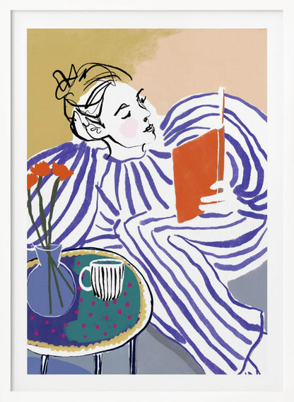 A stylized, framed illustration of a person with dark hair in a messy bun, wearing a blue and white striped top, reclining comfortably while engrossed in an orange book. Beside them is a small table with a blue vase holding three orange flowers and a black and white striped mug. The background is a soft beige color. Print