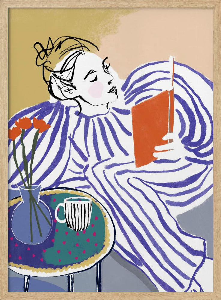 A stylized, framed illustration of a person with dark hair in a messy bun, wearing a blue and white striped top, reclining comfortably while engrossed in an orange book. Beside them is a small table with a blue vase holding three orange flowers and a black and white striped mug. The background is a soft beige color. Print