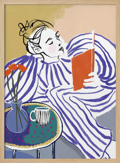 A stylized, framed illustration of a person with dark hair in a messy bun, wearing a blue and white striped top, reclining comfortably while engrossed in an orange book. Beside them is a small table with a blue vase holding three orange flowers and a black and white striped mug. The background is a soft beige color. Print