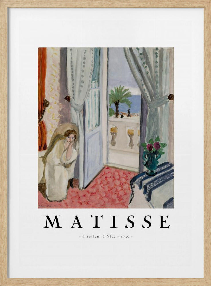 A framed art print of Henri Matisse's painting 'Intérieur à Nice - 1939'. The painting depicts a woman in a white robe sitting in a sunlit room with an open door leading to a balcony overlooking the sea and a palm tree. The poster has a white border with the artist's name and the title below the artwork. Artwork