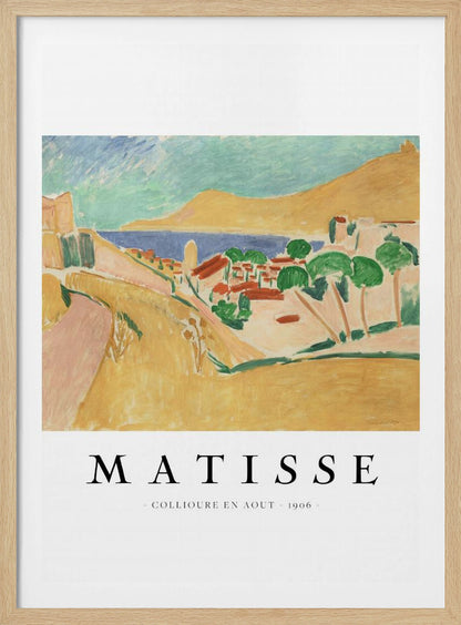 A poster featuring Henri Matisse's 1906 painting, 'Collioure en Aout'. The Fauvist artwork depicts a vibrant coastal landscape with yellow hills, a seaside village with red roofs, green trees, and a blue and turquoise sea. The poster has a black frame and white border with the artist's name and title underneath. Artwork