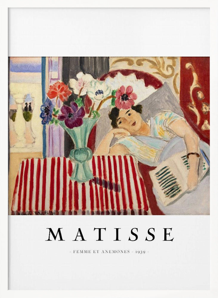 A poster featuring Henri Matisse's 1939 painting, 'Femme et Anemones'. The artwork depicts a woman in a colorful top reclining on a couch, holding a book. Beside her, on a red and white striped tablecloth, sits a vase filled with vibrant anemone flowers. The poster has a black frame and white matting, with 'MATISSE' printed below the image. Artwork