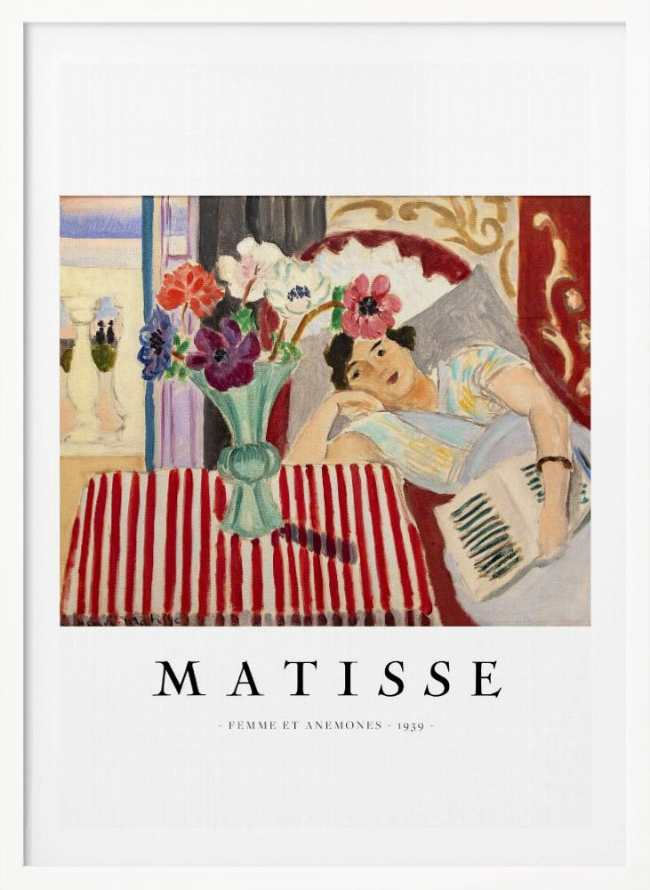 A poster featuring Henri Matisse's 1939 painting, 'Femme et Anemones'. The artwork depicts a woman in a colorful top reclining on a couch, holding a book. Beside her, on a red and white striped tablecloth, sits a vase filled with vibrant anemone flowers. The poster has a black frame and white matting, with 'MATISSE' printed below the image. Artwork