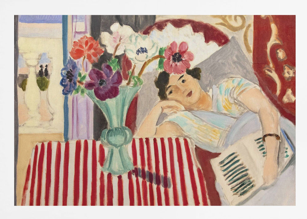 A Fauvist-style painting by Henri Matisse depicting a woman in a colorful blouse reclining with a book. Beside her is a table with a bold red-and-white striped cloth holding a light green vase with red, purple, and white anemone flowers. Print