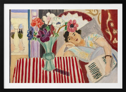 A Fauvist-style painting by Henri Matisse depicting a woman in a colorful blouse reclining with a book. Beside her is a table with a bold red-and-white striped cloth holding a light green vase with red, purple, and white anemone flowers. Print