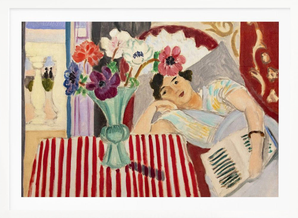 A Fauvist-style painting by Henri Matisse depicting a woman in a colorful blouse reclining with a book. Beside her is a table with a bold red-and-white striped cloth holding a light green vase with red, purple, and white anemone flowers. Print