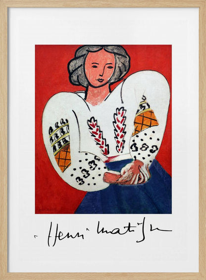 A framed art print of Henri Matisse's 'La Blouse Roumaine' (The Romanian Blouse). The painting depicts a woman with dark, styled hair against a vibrant solid red background. She is wearing a voluminous white blouse with puffy, intricately decorated sleeves and a dark blue skirt. Her hands are clasped in front of her. Below the image is the signature 'Henri Matisse'. Wall Art