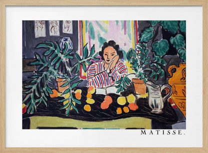 A framed print of the painting 'Woman with a Book' by Henri Matisse. The artwork features a woman in a red, white, and blue striped shirt sitting at a dark table filled with potted green plants and colorful fruit. She rests her head on her hand, looking out from the painting in a Fauvist style with bold colors and expressive brushwork. Poster
