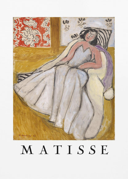 An art print poster of a Henri Matisse painting. The image features a woman with dark hair wearing a long, light-colored dress, reclining in a golden-yellow armchair. The background includes a red and white floral pattern and other decorative elements. The word 'MATISSE' is printed in large black letters below the artwork, all enclosed in a black frame. Decor