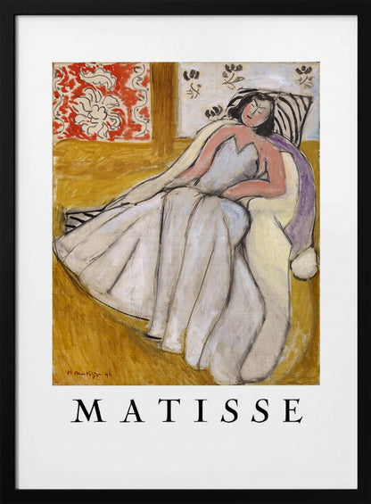 An art print poster of a Henri Matisse painting. The image features a woman with dark hair wearing a long, light-colored dress, reclining in a golden-yellow armchair. The background includes a red and white floral pattern and other decorative elements. The word 'MATISSE' is printed in large black letters below the artwork, all enclosed in a black frame. Decor